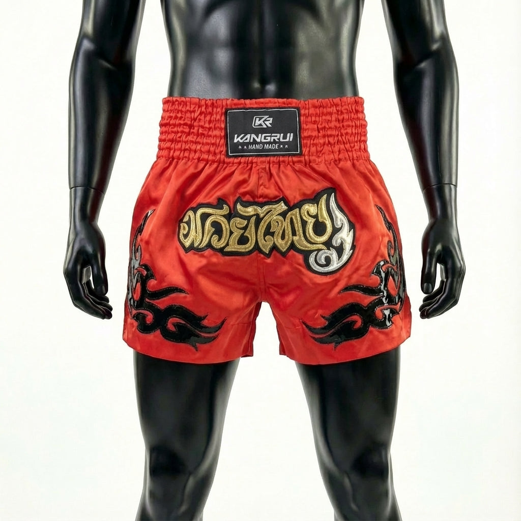 Red boxing shorts with black and gold designs on a mannequin against a white background