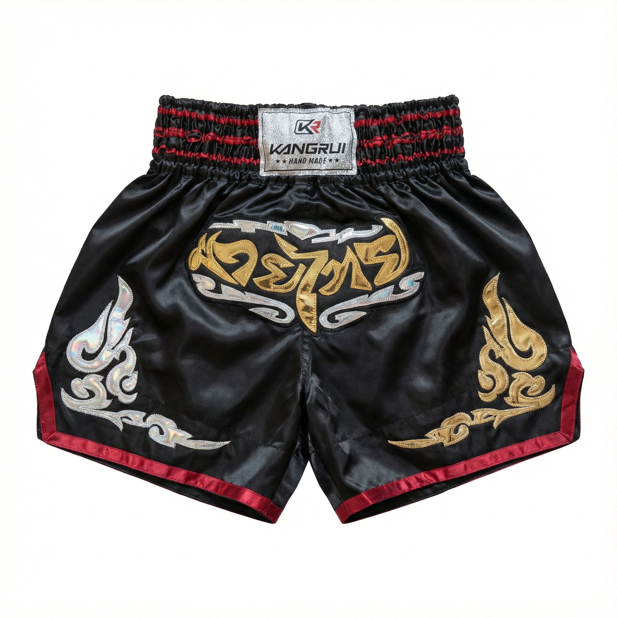 Black Muay Thai shorts with gold and red designs on a white background