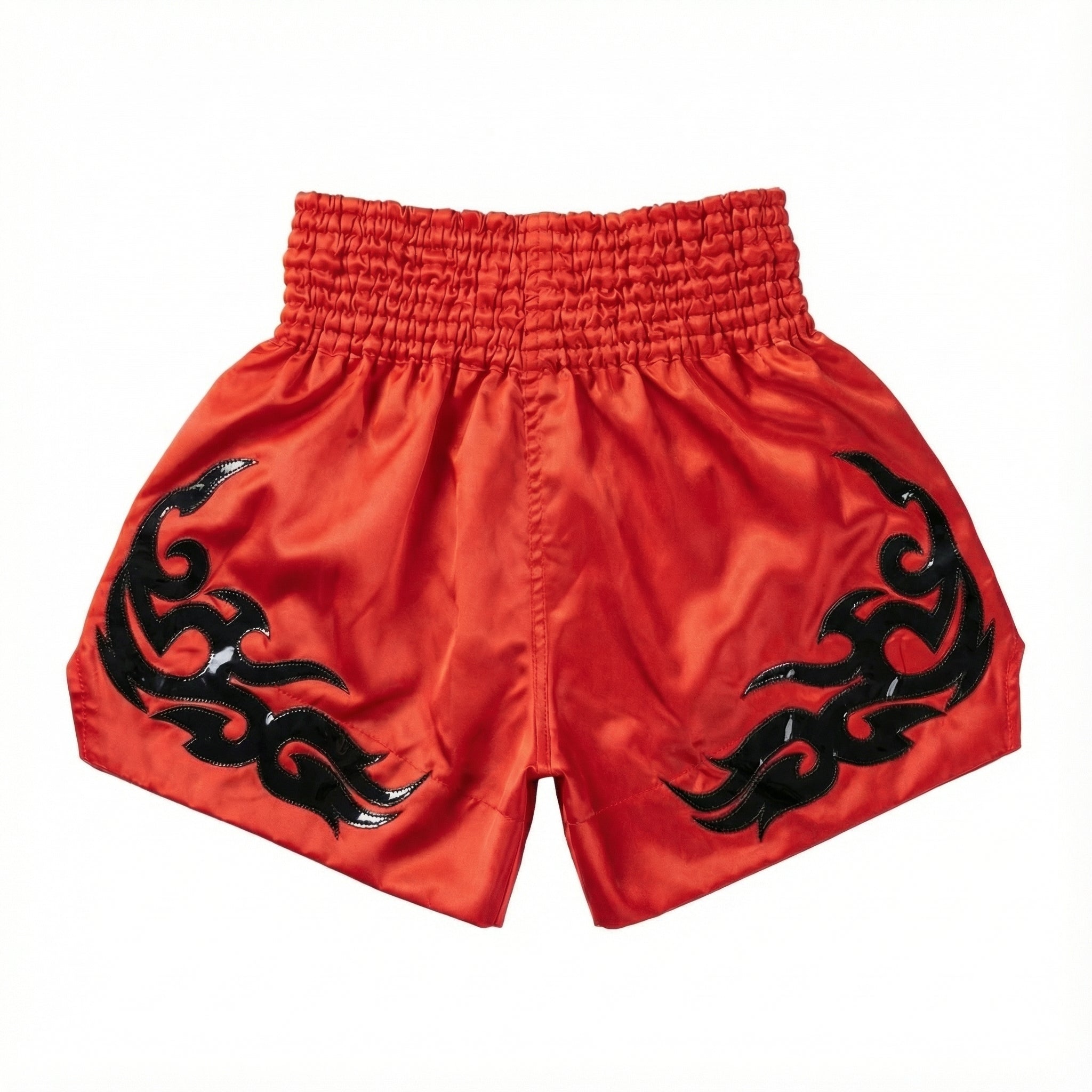 Red athletic shorts with black tribal designs on a white background