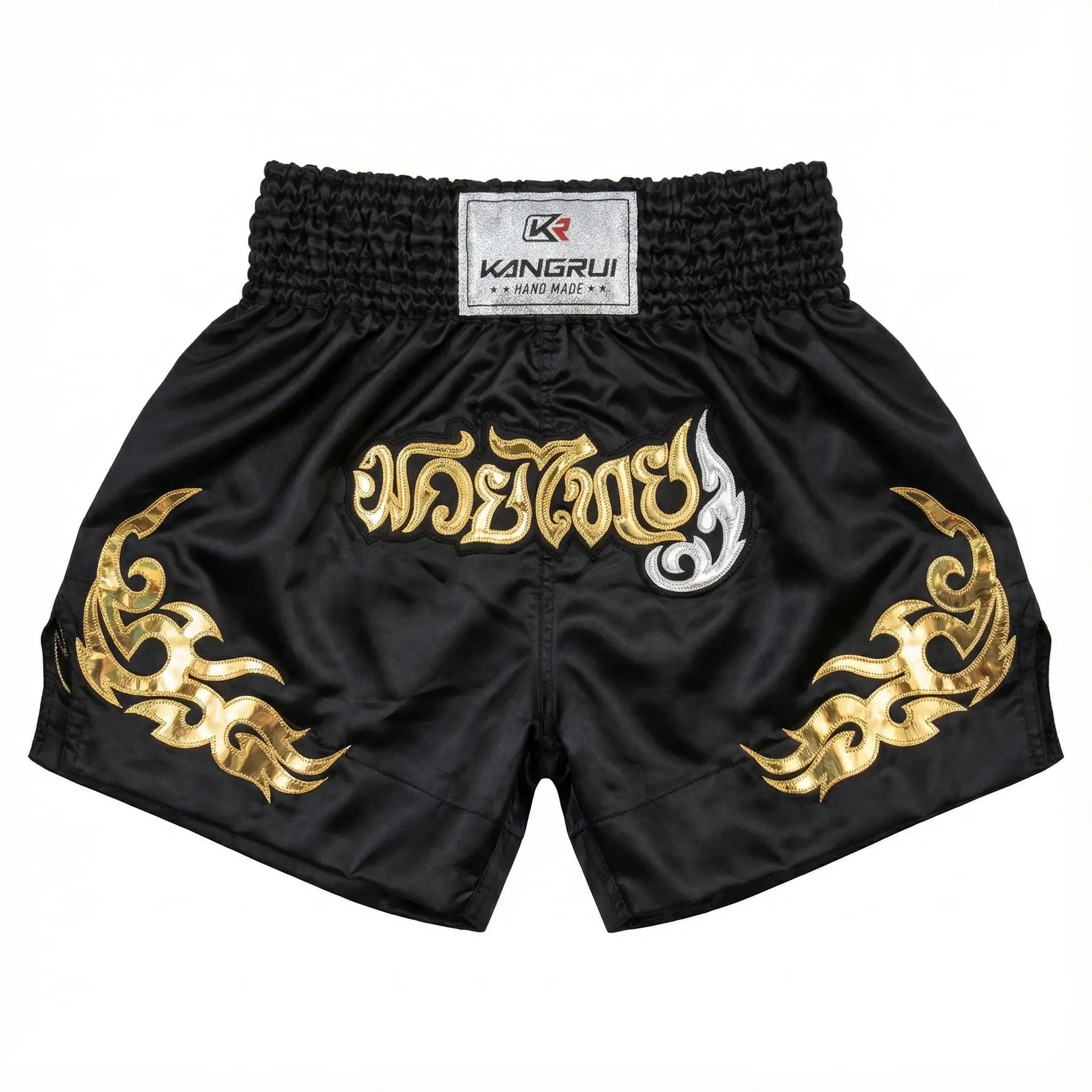 Black Muay Thai shorts with gold and white designs on a white background