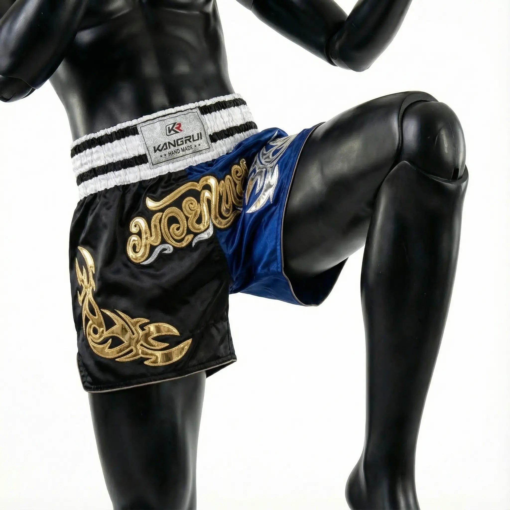 Black and blue boxing shorts with gold embroidery on a mannequin against a white background