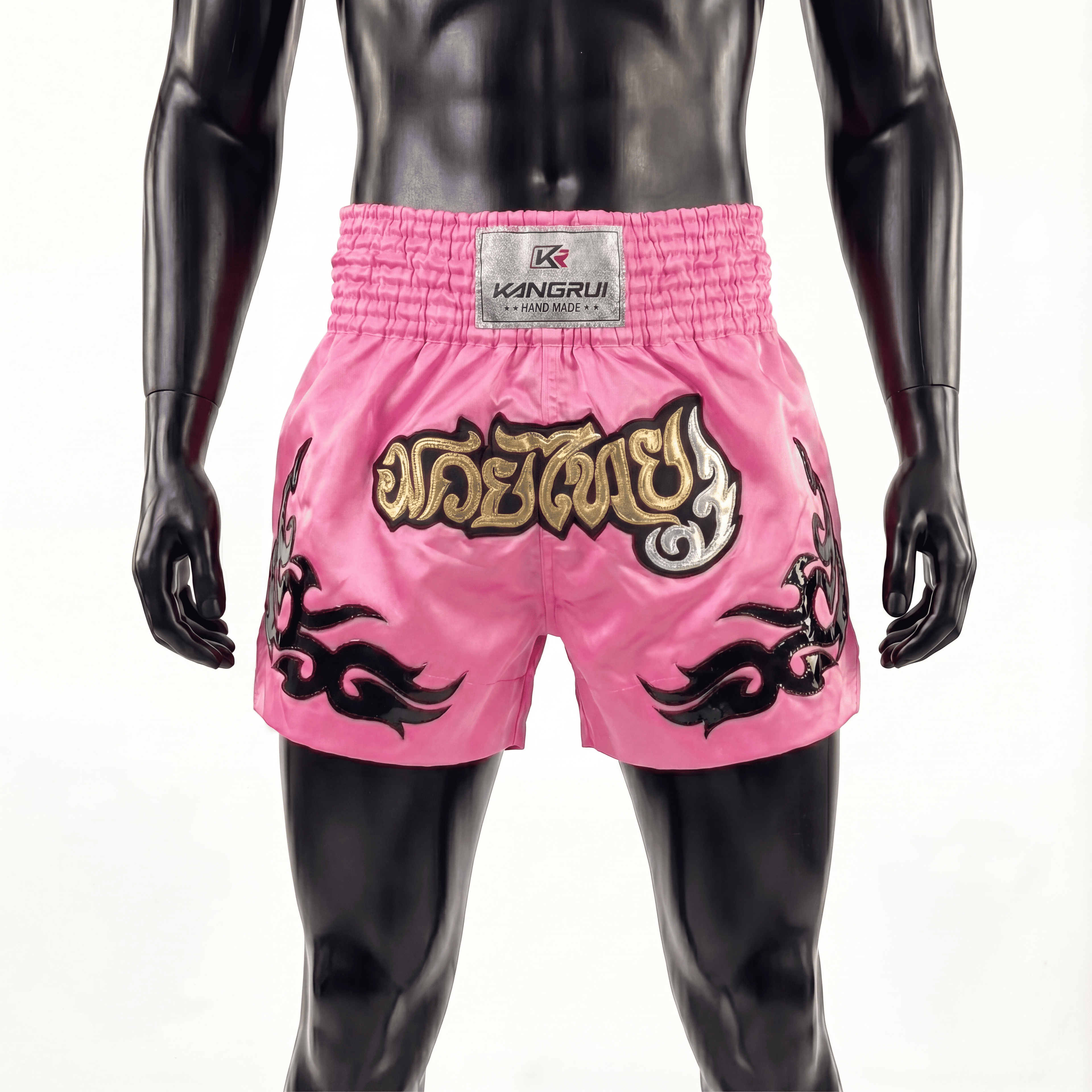 Pink boxing shorts with black and gold designs on a mannequin against a white background