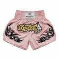 Pink Muay Thai shorts with black designs and a visible brand label on a white background