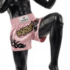 Pink boxing shorts with black designs on a mannequin against a white background