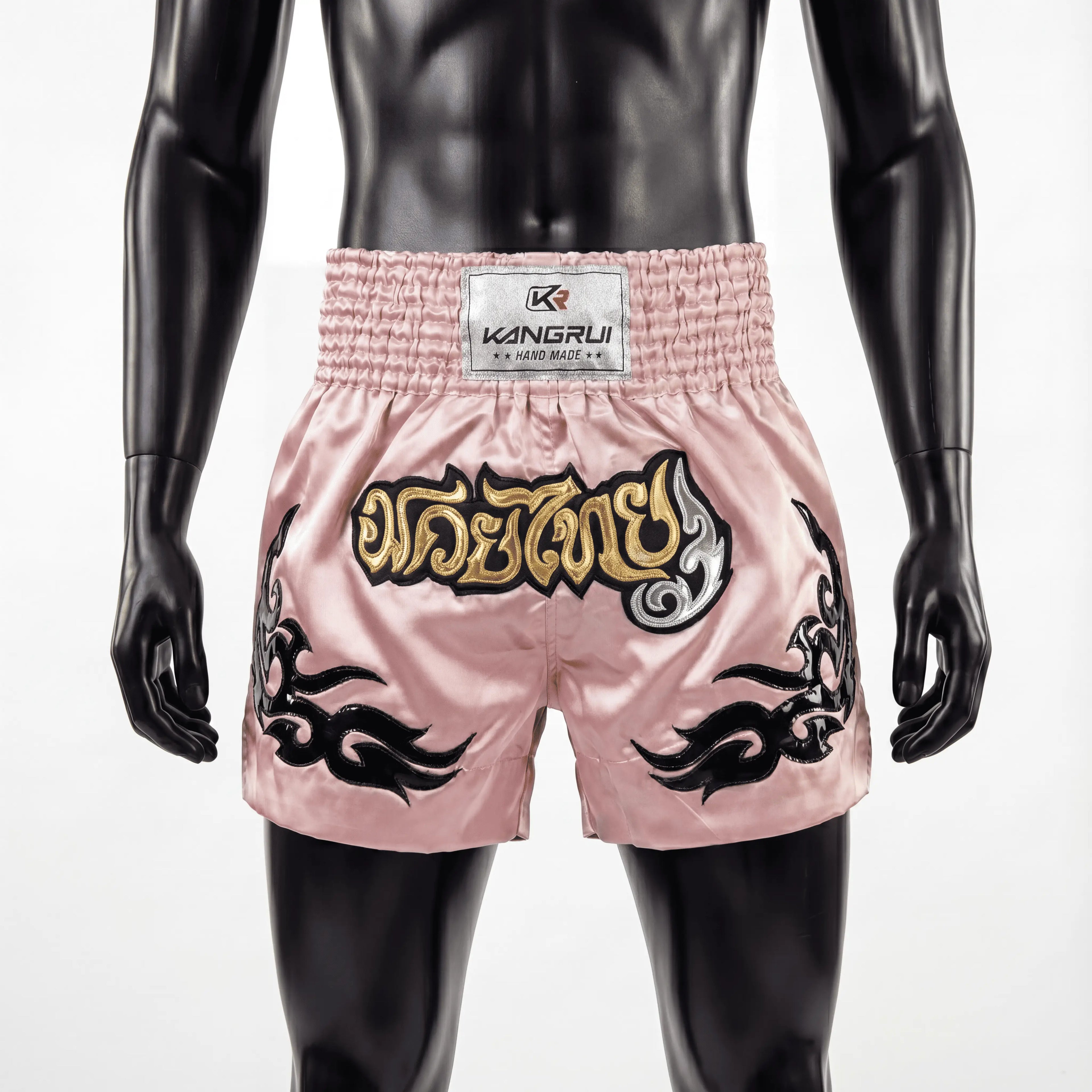 Pink boxing shorts with black designs and a visible brand label on a mannequin against a white background.