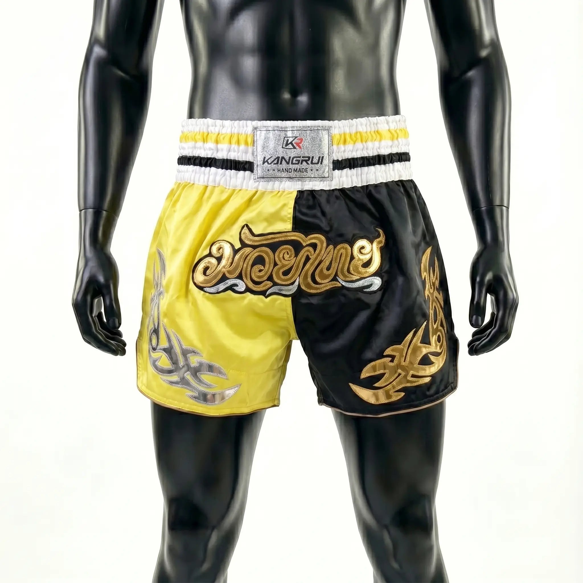 Black and yellow boxing shorts with gold designs on a mannequin against a white background